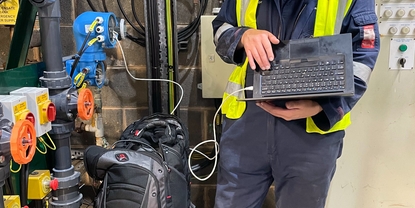 Engineer using a laptop to set up instrumentation in a plant